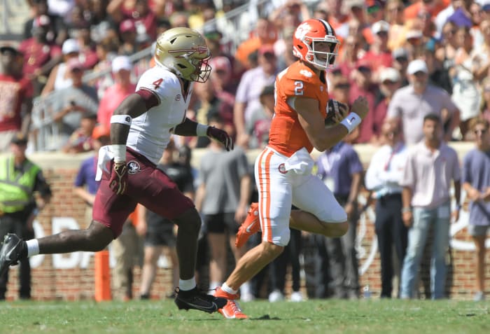 Clemson Tigers quarterback Cade Klubnik (2) runs against Florida State Seminoles linebacker Karen DeLoach (4) during the second quarter at Memorial Stadium.